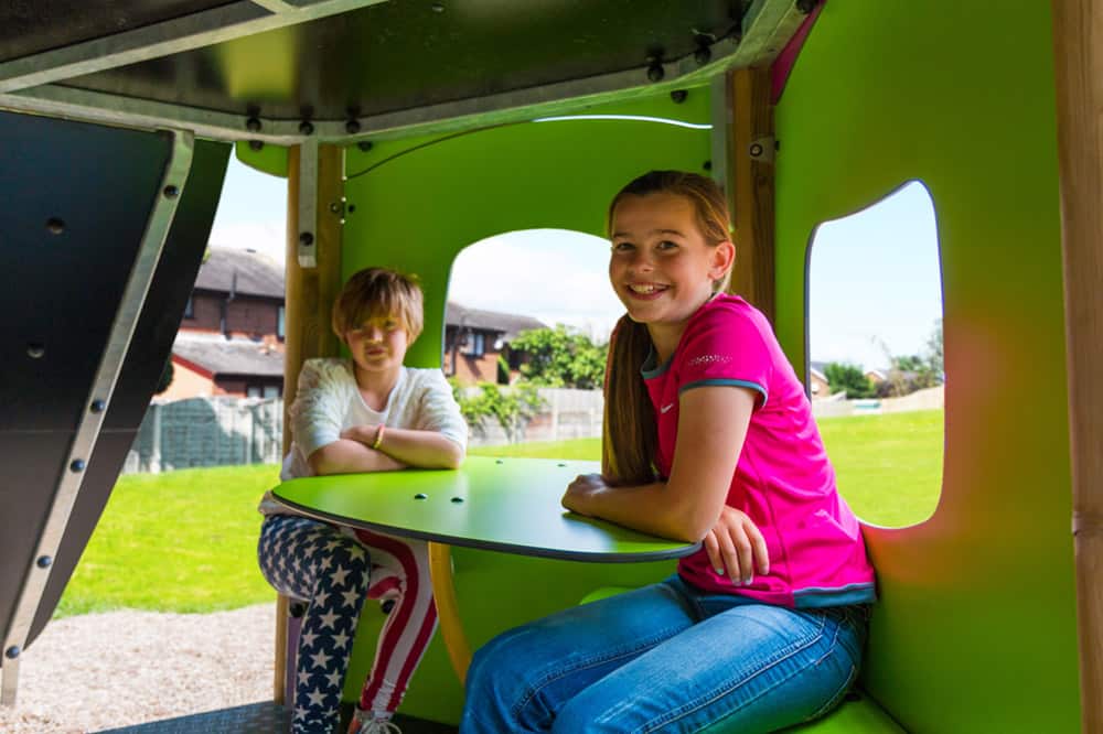 children sat in play equipment
