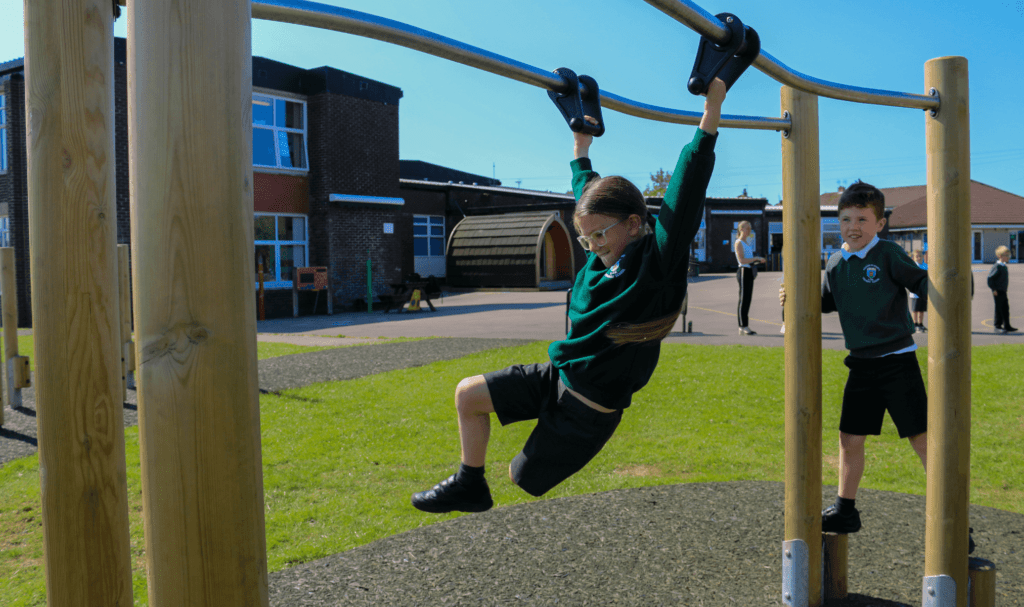 school children playing on playground equipment shuffle bars 