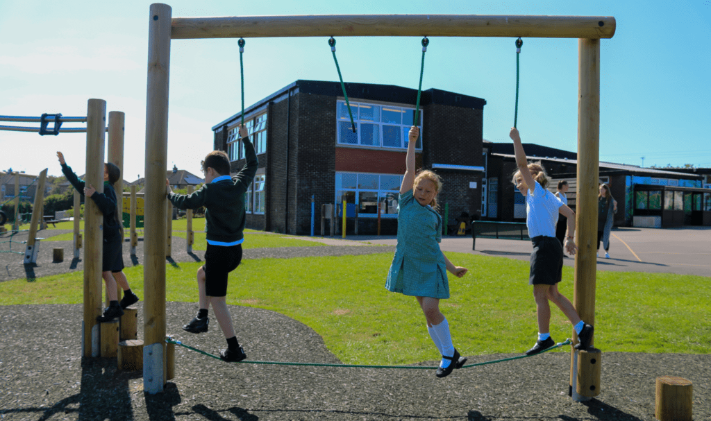 School children playing on new playground equipment