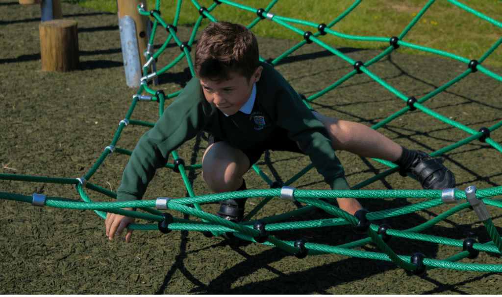 child moving across playground net 